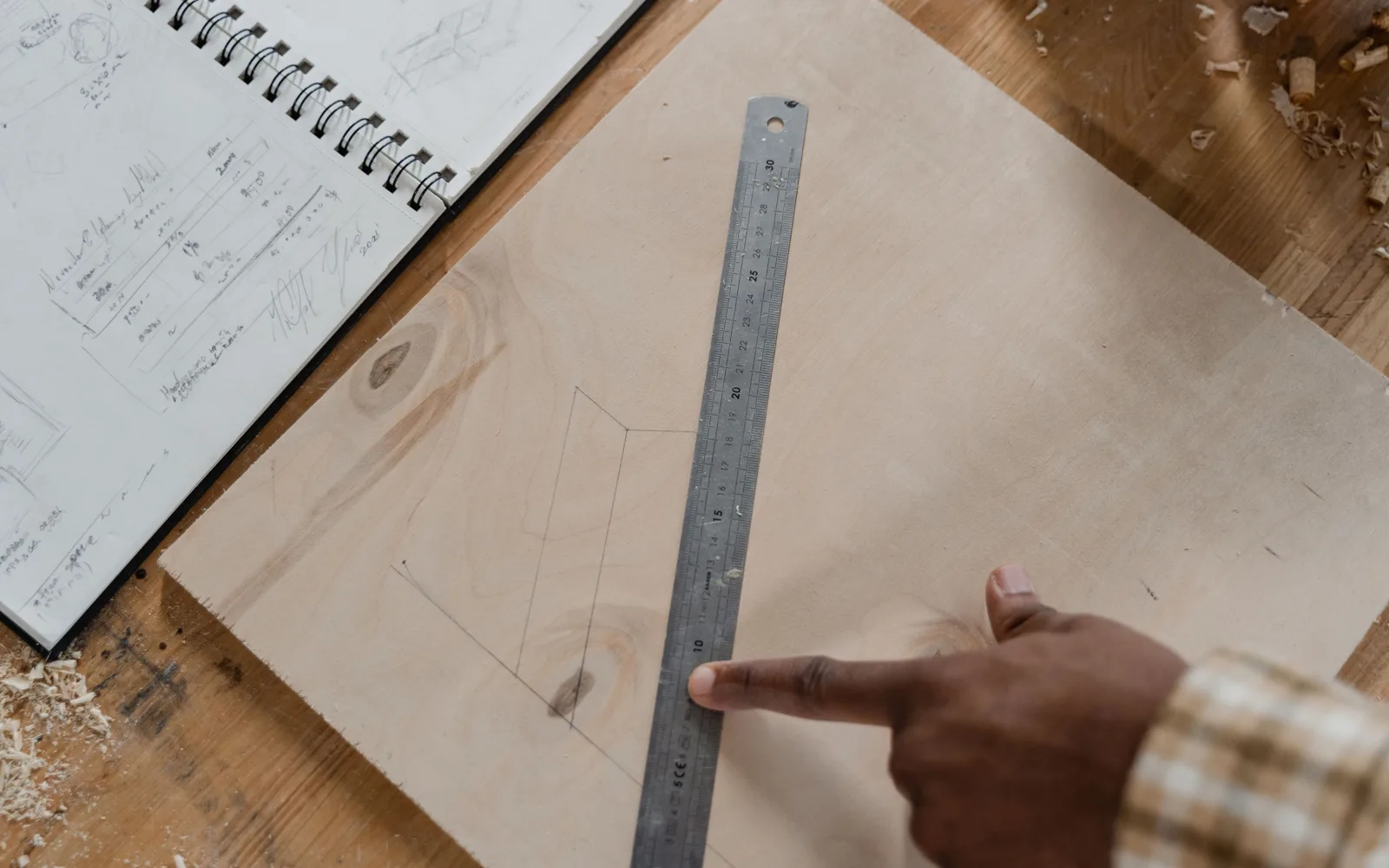 Carnet de chantier ouvert et crayon posés sur un établi